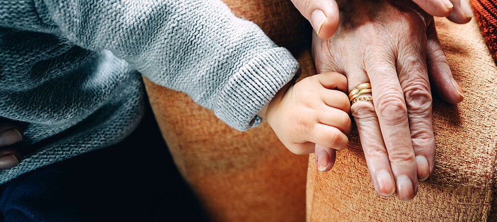 child holding hand with his grandparent